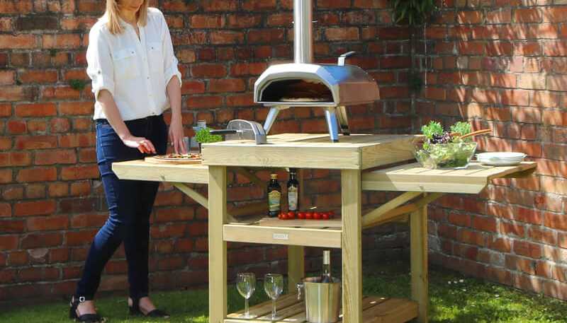 Lady prepping pizza on Zest's Garden Pizza Oven Table